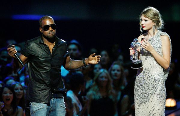   Cântăreața Kanye West ia microfonul de la cântăreața Taylor Swift în timp ce ea îl acceptă