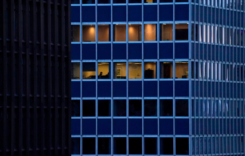 Edificio de oficinas de la ciudad de Nueva York, algunos oficinistas que trabajan a través de ventanas en diferentes pisos