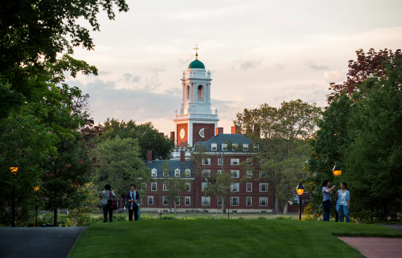   Campus de la Universidad de Harvard, patio cubierto de hierba con edificio de ladrillo en el fondo.