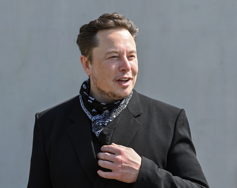  Elon Musk în costum și eșarfă cu model